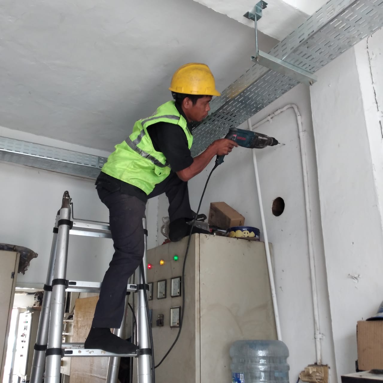 Field team drilling wall for cable installation